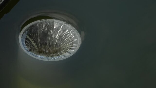 Water Being Sucked into an Industrial Drain Pipe, Close Up of Circular Water Vortex