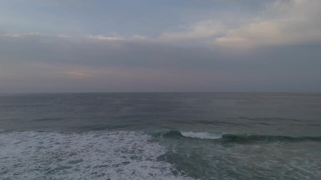 Low aerial flight over ocean waves at dawn on Pacific coast Oaxaca