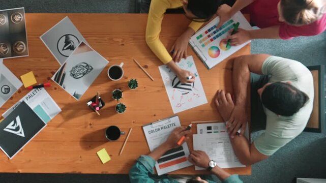 Top view of manager writing idea on sticky notes and explain idea about web design. Professional marketing team or programmer brainstorming idea while looking at tablet with color palette. Symposium.
