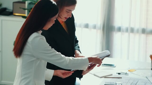 Top view of smart business woman talking and give house design. Aerial view of architect engineer looking at blueprint and building structure at table with safety helmet and house model. Alimentation.