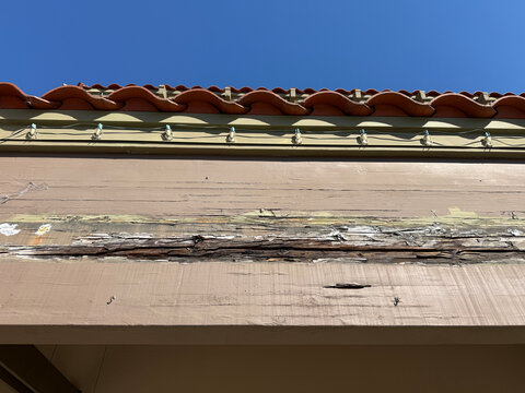 Weathered wooden roof fascia with peeling paint