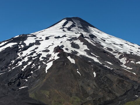 Aerial close-up of Villarrica volcano summit with snow and lava rock