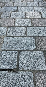 灰色の花崗岩の切石を互い違いに敷いた石畳の路面のテクスチャ(縦位置)