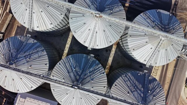 Metal umbrellas with radial frames cover market stalls in rows, seen from above at an outdoor market during daylight.