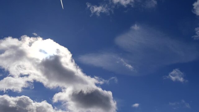 飛行機がフレームイン　雲からまぶしい太陽がでてくる空