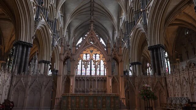 Gothic arches, organ pipes and the ornate high altar of Lincoln Cathedral fill the frame as the camera slowly moves inward.