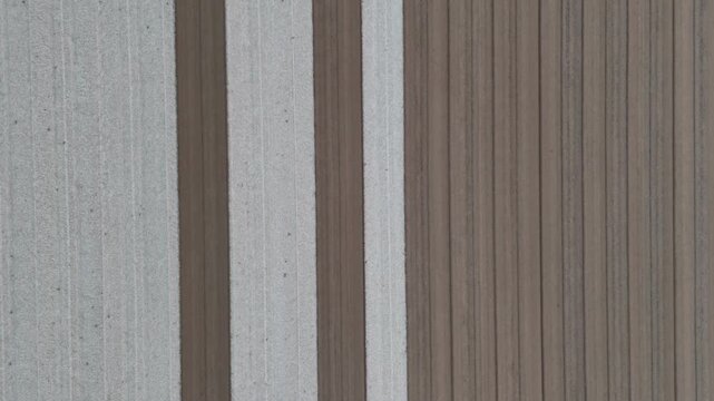 Parallel cultivation furrows and contrasting soil strips form geometric patterns across agricultural fields near Monticelli d'Ongina and Castelvetro Piacentino, Piacenza, Emilia-Romagna, Italy, top do