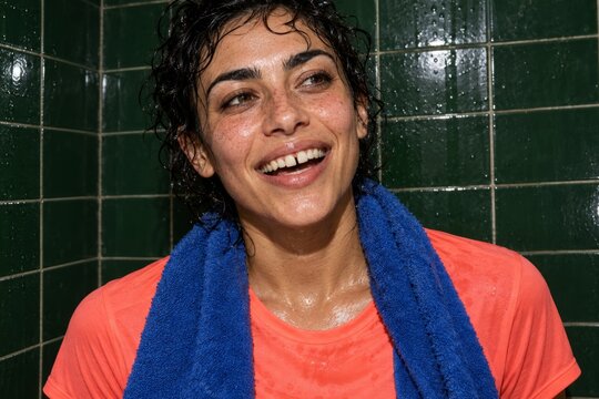 smiling athlete with a blue towel after exercise