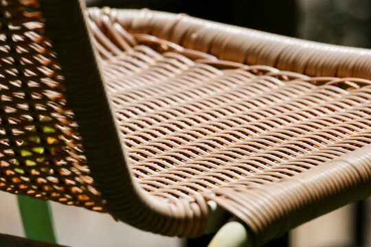 Woven rattan chair with intricate natural fiber pattern and warm brown texture, close up indoor furniture detail creating calm handcrafted atmosphere with soft natural light and shadow