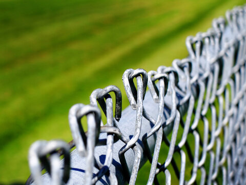 Closeup of Chainlink Fence Top with Bent Metal Next to Pole for Safety and Security