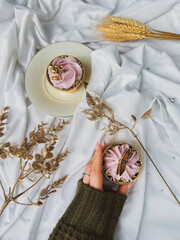 cupcakes, pink frosting, frosted dessert, buttercream swirl, sweet treats, mini cakes, gold decorations, butterfly ornament, dessert styling, icing, decorative toppings, round pastry, cream plate, gol © Deeana Arts