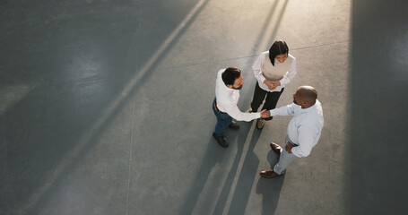 Business, partnership and people in office with handshake, greeting and negotiation in b2b deal. Space, above and employees in agency with shaking hands, introduction and agreement in collaboration. © peopleimages.com
