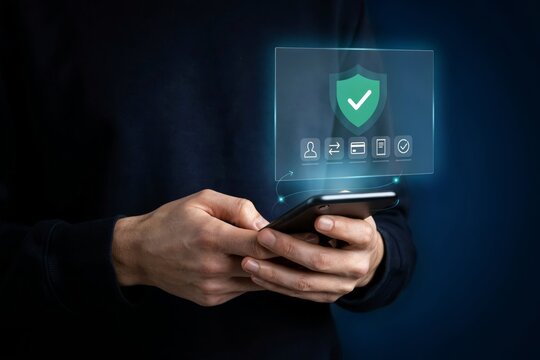 Person using a smartphone with a digital security shield icon interface representing data protection, secure payments, and privacy