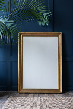 Large gold frame with blank canvas against navy wall