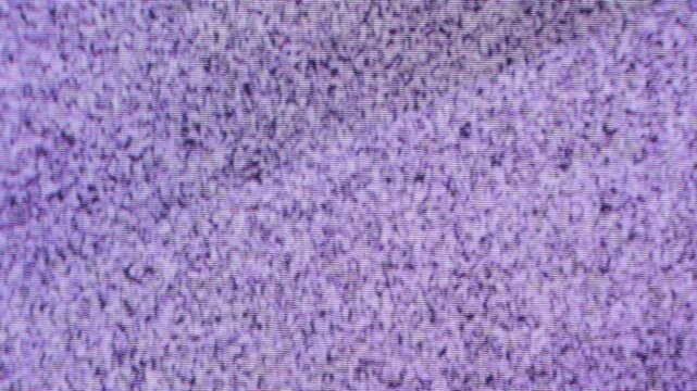 An old television, turned on but with no signal, gray static moving, varying in its image, a square, large, and well-maintained television