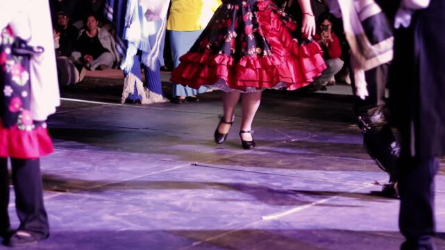 Legs of people in folk costumes, dancing and stomping. Very joyful, they dance the Cueca, a typical Chilean dance that represents Chilean identity. National holidays.