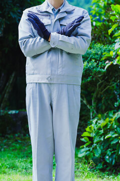 自然の背景でNGポーズする作業服の男性