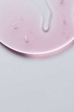 Pink cosmetic product for skin care. A serum or body gel or a moisturizer. Copy space