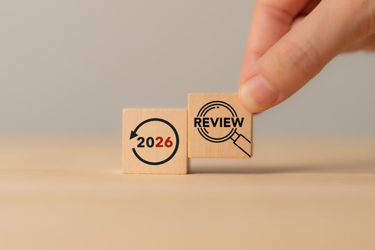 2026 Year in Review. Annual Business Performance Evaluation and Analysis. Placing a wooden review block beside 2026. Annual performance evaluation, year-end reflection, business analysis, assessment.