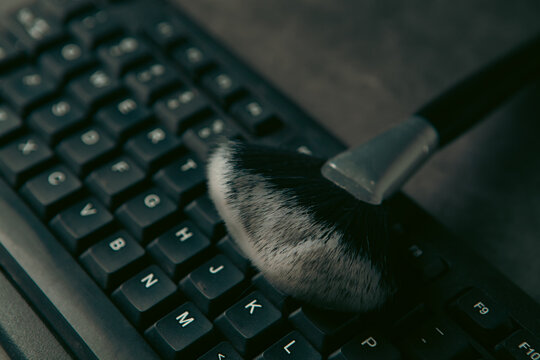 Keyboard and brush on a dark background.
