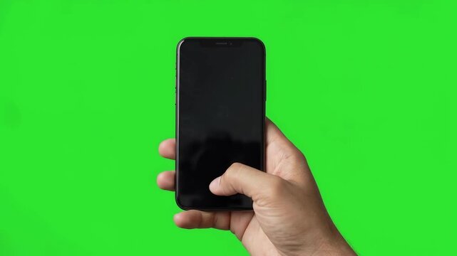 Hand holding smartphone and scrolling with thumb on green screen