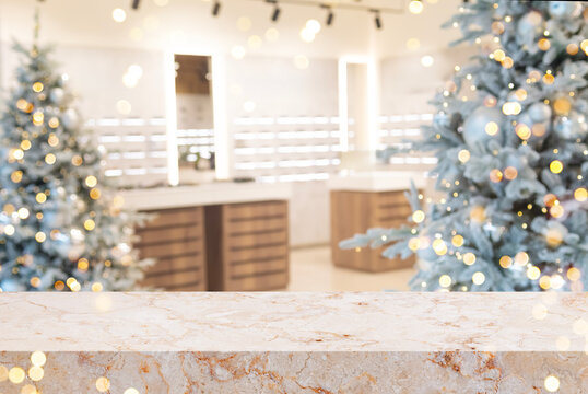 Marble countertop for product placement with blurred modern shop interior with Christmas trees as background