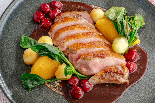 Gourmet roasted duck breast with cherry sauce and vegetables