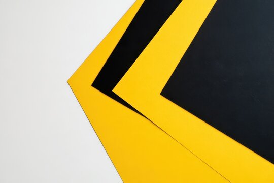 Bold yellow and black construction paper layered in a clean flat lay on white background