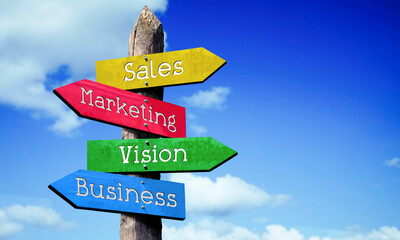 Sales, marketing, vision, business - wooden signpost with four arrows, sky with clouds © PX Media