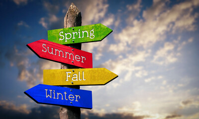 Spring, Summer, Fall, Winter - wooden signpost with four arrows, sky with clouds © PX Media