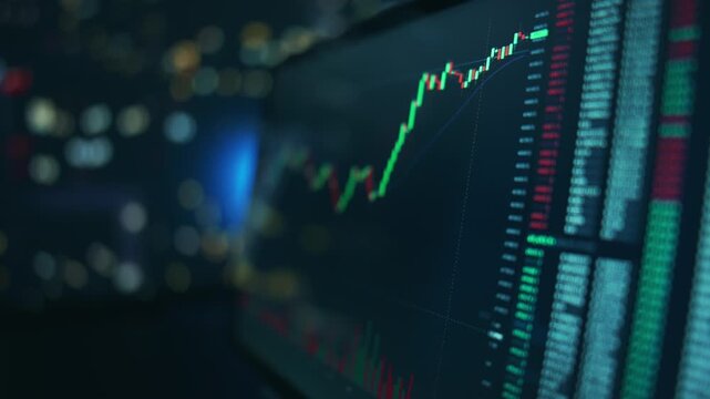 Trading candles on a tablet screen held in hands. Mobile investing and price changes