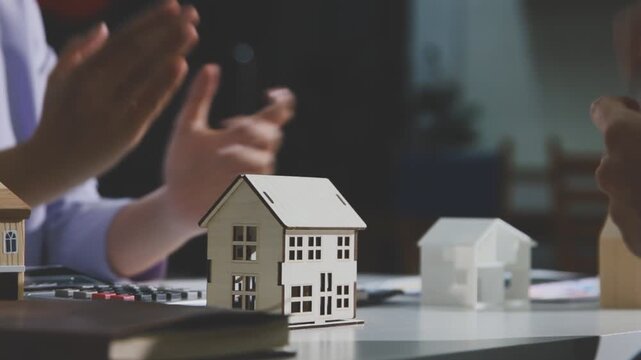 Business professionals meet with real estate agents to discuss real estate investments, sign contracts, apply for mortgages, plan purchases, ownership, and successfully secure approval for