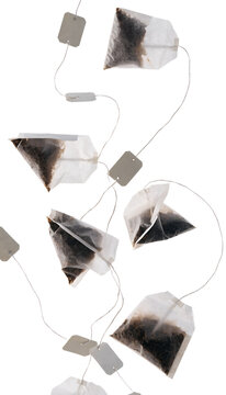 Multiple generic tea bags levitating in swirling motion isolated on a transparent background