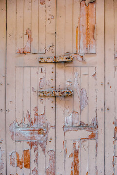 Vertical Faded Wooden Shutters with Severe Peeling Paint, Wood Grain, and Rusty Metal Hasp Plates