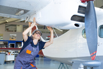 Woman aircraft mechanic performing propeller airplane maintenance © luisrojasstock