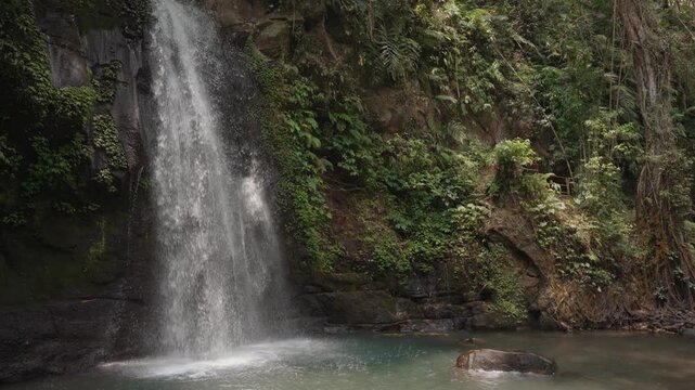 Ulu Petanu Waterfall Cascading Down a Rocky Cliff Amid Lush Tropical Forest in Slow Motion, Tegallalang, Bali, Indonesia