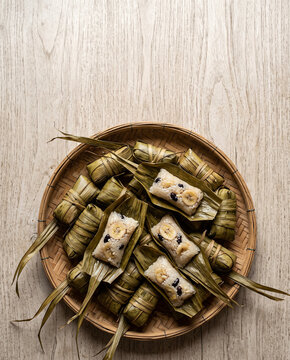 Khao tom luk yon palm leaf wrapped sticky rice for Ok Phansa end of Buddhist Lent, vertical top view copy space
