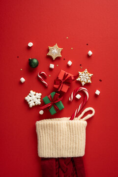 Merry Christmas and Happy New Year stocking filled with gift cookie and candycane on vertical red background