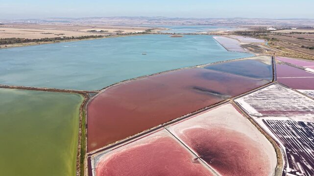 Aerial view of the colorful salt pans with distinct mineral-rich water pools and geometric dikes in Burgas, Burgas, Bulgaria.