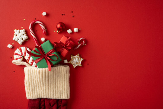 Merry Christmas and Happy New Year stocking filled with gifts candy canes cookies and festive decorations on placard background with empty space