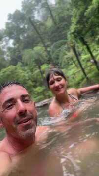 Couple relaxing in caldeira velha thermal pool, sao miguel