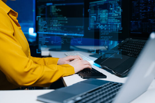 Programmer using stylus and laptop to write code at night. Coding workspace with tablet, monitor, and dark theme