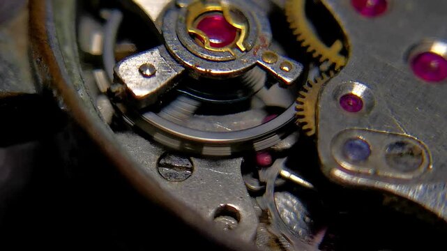 Macro footage of escape wheel and balance spring oscillating inside clockwork