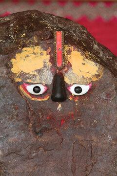 The sacred stone of Mount Govardhan, revered as Giriraj&mdash;a form of Krishna&mdash;adorned with eyes and a tilak in Goverdan.