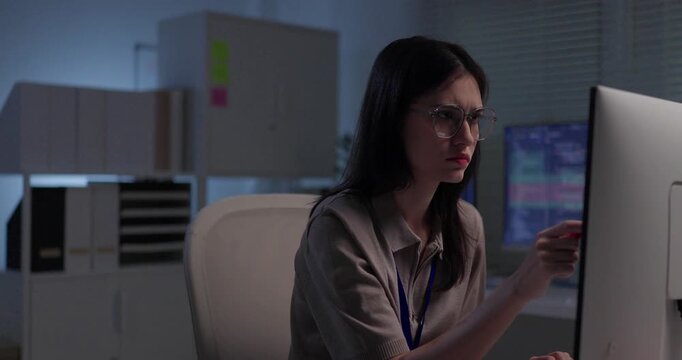 Worried woman software developer staring at code on monitor and thinking through problem