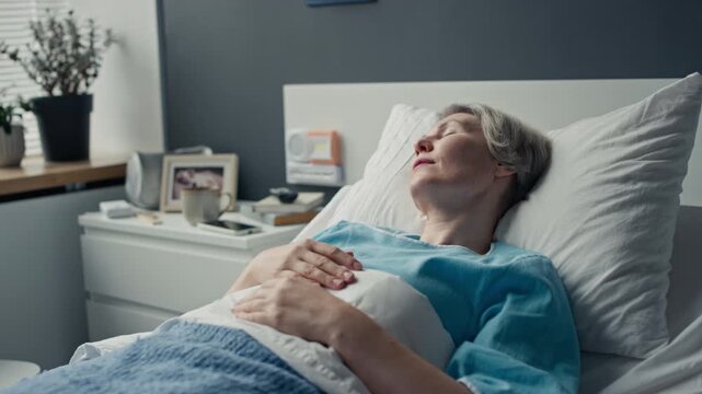 Middle aged Caucasian woman resting in hospital bed during medical rehabilitation. Clip suitable for healthcare campaigns, patient care tutorials, and insurance advertising