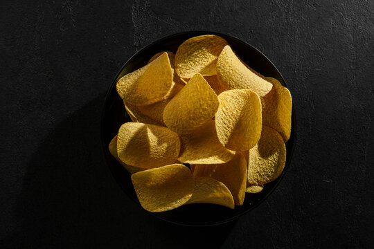 pringles chips on a black background