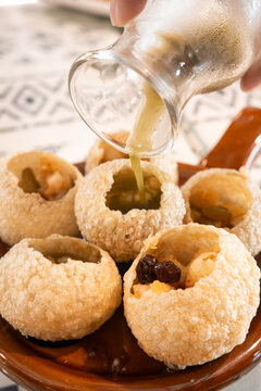 Traditional Indian panipuri golgappa snack served with mint flavored water.