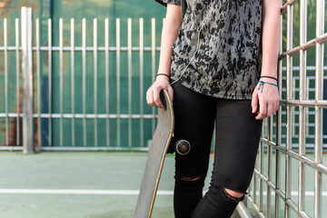 Casual skateboarder leaning on fence © Rawpixel.com