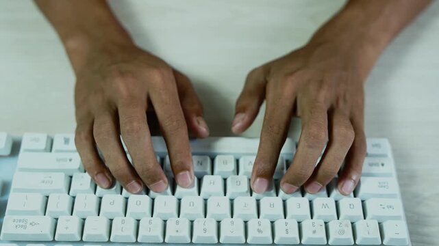 Hands typing on a white computer keyboard, Close-up overhead view of hands typing on a white computer keyboard at a clean desk, showing work, communication, technology, and digital productivity.